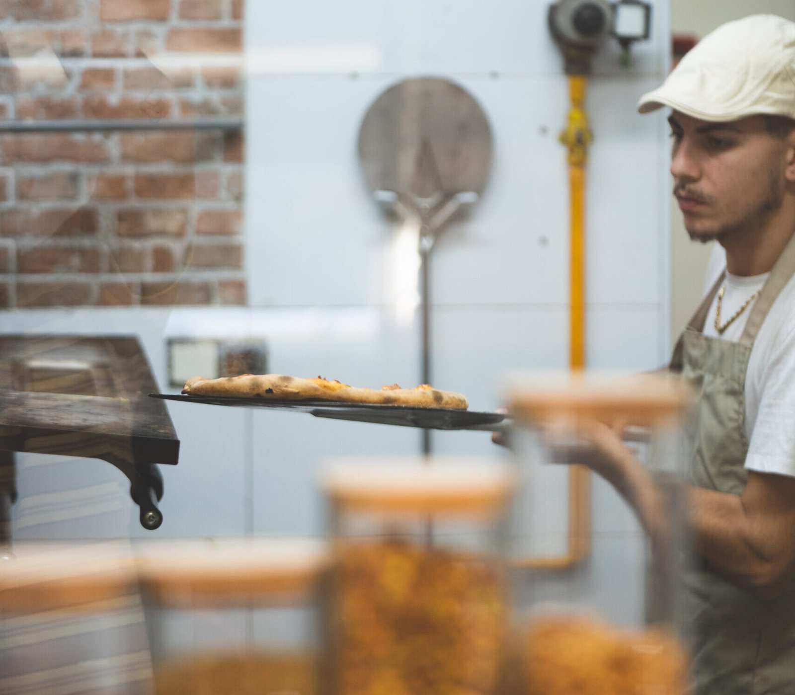 Pizzero sacando pizza del horno